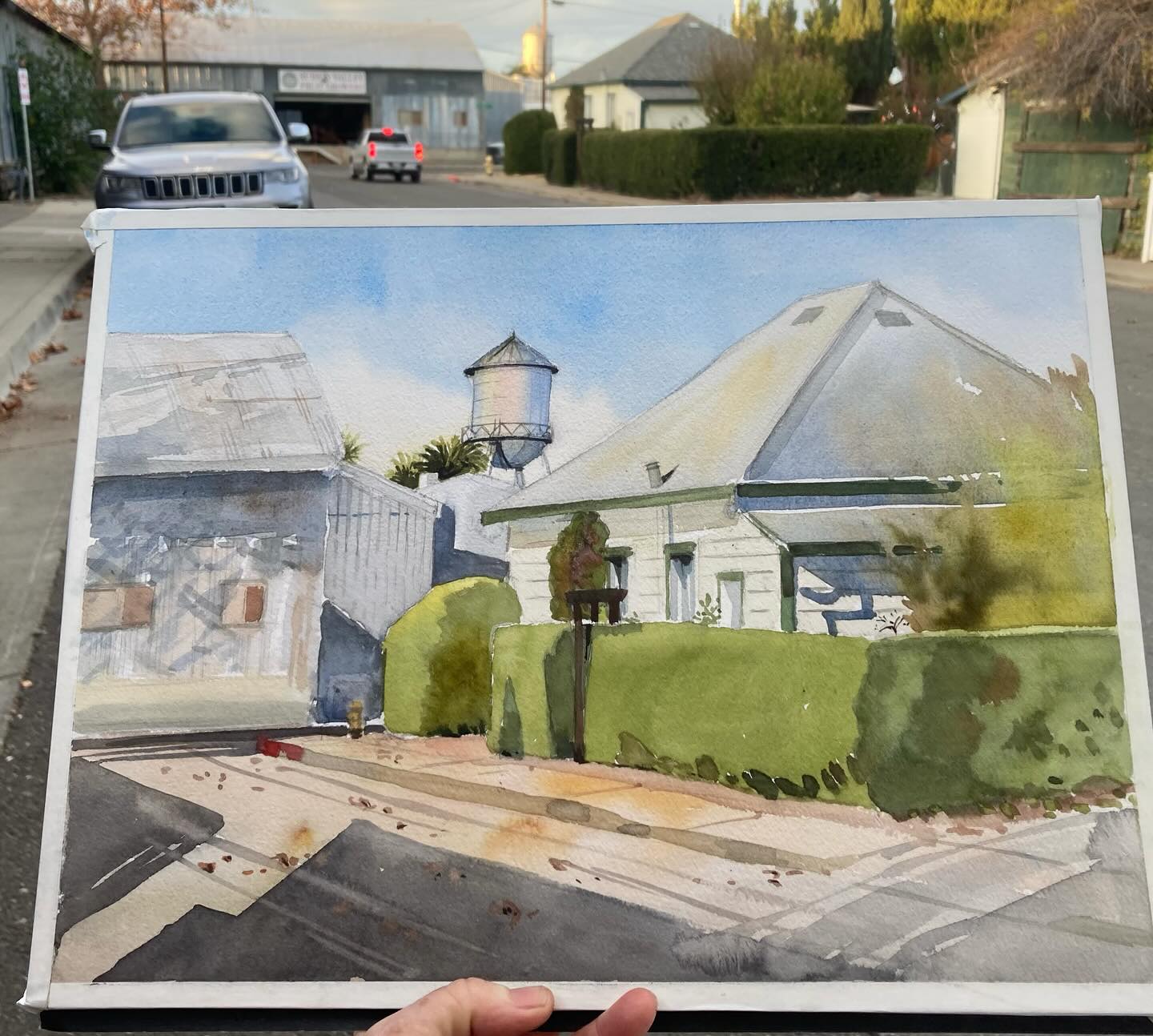 The plein air watercolor painting, with the house / subject in the background