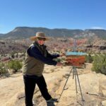 photo of artist painting en plein air in the desert landscape