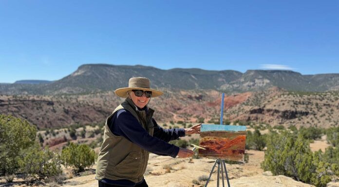 photo of artist painting en plein air in the desert landscape