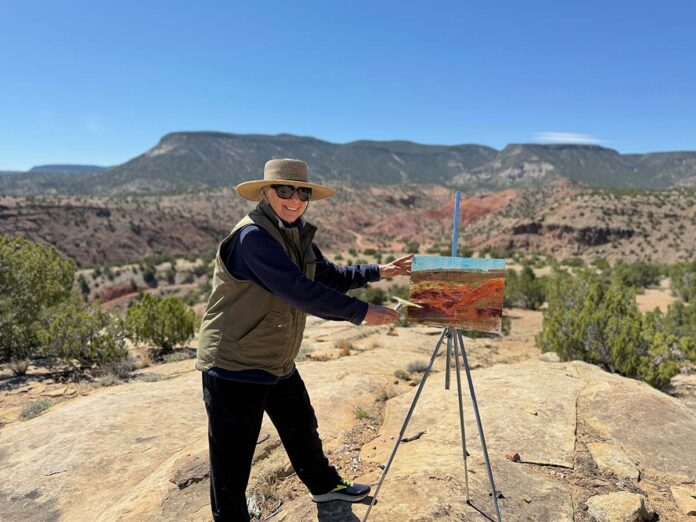 photo of artist painting en plein air in the desert landscape